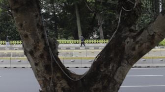 Pekerja berjalan di kawasan Dukuh Atas, Jakarta, Rabu (6/1/2021). [Suara.com/Angga Budhiyanto]