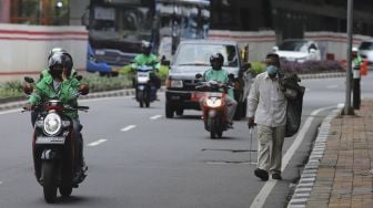 Penyandang Masalah Kesejahteraan Sosial (PMKS) berjalan di kawasan Kuningan, Jakarta, Kamis (7/1/2021). [Suara.com/Angga Budhiyanto]