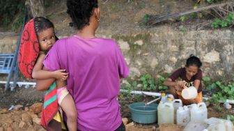 Warga suku Bajo mengisi air bersih ke dalam jirigen di Desa Leppe, Kecamatan Soropia, Kabupaten Konawe, Sulawesi Tenggara, Sabtu (9/1/2021).  ANTARA FOTO/Jojon
