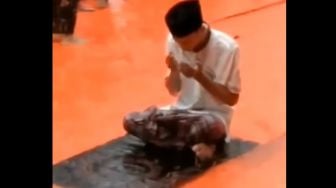 Viral! Ikut Salat Jumat, Pria Ini Tetap Berdoa Meskipun Basah Diguyur Hujan