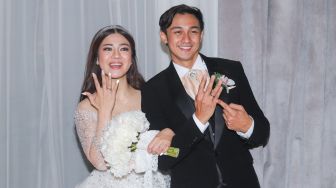 Pasangan Caesar Hito dan Felicya Angelista menunjukkan cincin kawin mereka usai melangsungkan pernikahan di Kawasan Darmawangsa, Jakarta Selatan, Sabtu (9/1/2021). [Suara.com/Alfian Winanto]