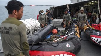 Sejumlah prajurit Batalyon Intai Amfibi 1 Korps Marinir (Yontaifib 1 Mar) TNI AL menyiapkan perahu karet di atas geladak KRI Teluk Gilimanuk-531 untuk pencarian pesawat Sriwijaya Air SJ 182 yang hilang kontak di perairan Kepulauan Seribu, Jakarta, Minggu (10/1/2021). [ANTARA FOTO/M Risyal Hidayat]
