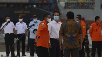 Wakil Ketua DPR Azis Syamsuddin (tengah) berbincang dengan Kepala Basarnas Bagus Puruhito (kiri) usai memberikan keterangan kepada awak media saat meninjau penanganan evakuasi pesawat Sriwijaya Air SJ 182 di Dermaga JICT, Tanjung Priok, Jakarta, Senin (11/1/2021). [Suara.com/Angga Budhiyanto]