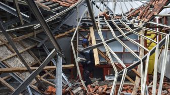 Petugas menyelamatkan barang-barang sekolah pasca ambruknya atap ruang kelas SDN 2 Janggala di Dusun Sukalilah, Kecamatan Cidolong, Kabupaten Ciamis, Jawa Barat, Senin (11/1/2021). [ANTARA FOTO/Adeng Bustomi]