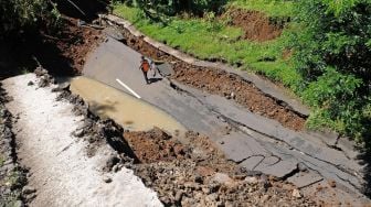 Sejumlah petugas Kementerian Pekerjaan Umum Bina Marga Wonosobo mengamati lokasi tanah longsor di jalan raya Wonosobo-Kebumen Desa Trimulyo, Wadaslintang, Wonosobo, Jawa Tengah, Selasa (12/1/2021). [ANTARA FOTO/Anis Efizudin]
