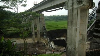 Petugas PT KAI memeriksa jembatan rel Kereta Api (KA) yang ambruk di Dukuh Timbang, Desa Tonjong, Brebes, Jawa Tengah, Selasa (12/1/2021). [ANTARA FOTO/Oky Lukmansyah]