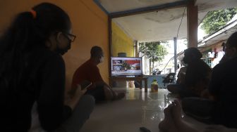 Warga menonton televisi yang menayangkan langsung penyuntikan vaksin CoronaVac perdana di Jakarta, Rabu (13/1/2021). [Suara.com/Angga Budhiyanto]