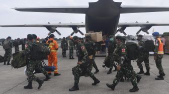 Prajurit TNI bersiap memasuki Pesawat Hercules A 1321 TNI AU yang membawa bantuan logistik untuk korban gempa bumi Majene di Lanud Halim Perdanakusuma, Jakarta, Jumat (15/1/2021). [ANTARA FOTO/Sigid Kurniawan]