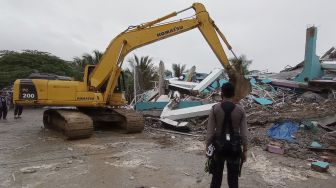 Petugas menggunakan alat berat memindahkan puing bangunan RS Mitra Manakarra yang rusak pascagempa bumi, di Mamuju, Sulawesi Barat, Jumat (15/1/2021). [ANTARA FOTO/Akbar Tado]