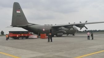 Petugas memasukkan logistik bantuan untuk korban gempa bumi Majene kedalam Pesawat Hercules A 1321 TNI AU, di Lanud Halim Perdanakusuma, Jakarta, Jumat (15/1/2021).  [ANTARA FOTO/Sigid Kurniawan]