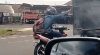 Unik Tapi Berbahaya, Pemotor Pegangan Truk di Jalan saat Kehabisan Bensin