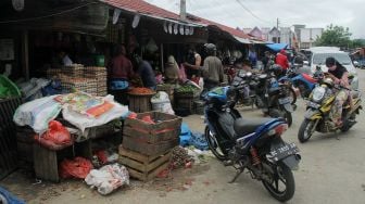 Penjual menawarkan barang dagangannya di pasar baru Mamuju, Sulawesi Barat, Minggu (17/1/2021).  ANTARA FOTO/ Akbar Tado
