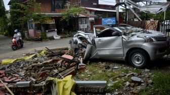 Sebuah mobil rusak terdampak akibat gempa bumi di Kabupaten Mamuju, Sulawesi Barat, Minggu (17/1/2021). [ANTARA FOTO/Abriawan Abhe]
