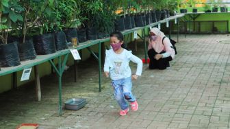 Anak - anak bermain saat berwisata di Agro Wisata Ragunan, Jakarta Selatan, Minggu (17/1/2021). [Suara.com/Alfian Winanto]