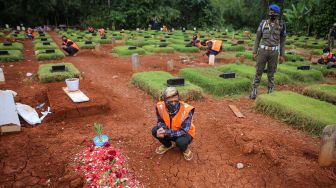 Sejumlah pelanggar protokol kesehatan COVID-19 berdoa saat penerapan sanksi di TPU Jombang, Kota Tangerang Selatan, Banten, Senin (18/1/2021).  ANTARA FOTO/Fauzan
