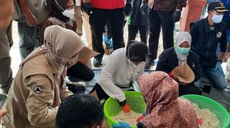 Pantau Dapur Umum Korban Banjir Jember, Mensos Risma Pegang Centong Nasi