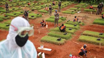 Sejumlah pelanggar protokol kesehatan COVID-19 berdoa saat penerapan sanksi di TPU Jombang, Kota Tangerang Selatan, Banten, Senin (18/1/2021).  ANTARA FOTO/Fauzan
