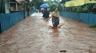 Warga menerobos banjir di Kecamatan Kabaena Selatan, Kabupaten Bombana, Sulawesi Tenggara, Senin [ANTARA FOTO]