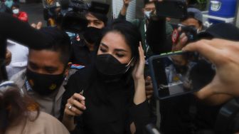 Penyanyi Nindy Ayunda berjalan menerobos awak media setelah menjalani pemeriksaan sebagai saksi terkait kasus narkoba yang menjerat suaminya, Askara Parasady Harsono di Polres Metro Jakarta Barat, Selasa (19/1/2021). [Suara.com/Alfian Winanto]