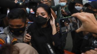 Penyanyi Nindy Ayunda berjalan menerobos awak media setelah menjalani pemeriksaan sebagai saksi terkait kasus narkoba yang menjerat suaminya, Askara Parasady Harsono di Polres Metro Jakarta Barat, Selasa (19/1/2021). [Suara.com/Alfian Winanto]