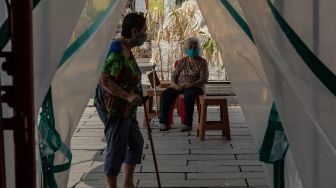 Warga lanjut usia (lansia) menunjukkan angpau yang diterimanya dari Yayasan Kelenteng Tay Kak Sie, Semarang, Jawa Tengah, Jumat (22/1/2021).  [ANTARA FOTO/Aji Styawan]