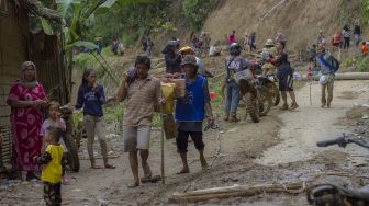 Warga membawa logistik bantuan korban bencana banjir bandang, di Desa Arangani, Kabupaten Hulu Sungai Tengah, Kalimantan Selatan, Jumat (22/1/2021). [ANTARA FOTO/Bayu Pratama S]