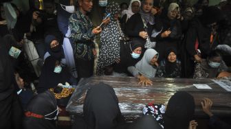 Keluarga memegang peti jenazah Angga Fernanda Afriyon di Sungai Sapiah, Padang, Sumatera Barat, Sabtu (23/1/2021). [ANTARA/Iggoy el Fitra]