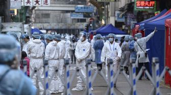 Petugas kesehatan bersiap untuk melakukan pengujian di daerah Yordania, Hong Kong, Sabtu (23/1/2021). [Peter PARKS / AFP]