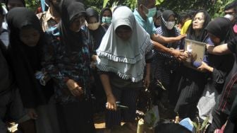 Keluarga dan kerabat menghadiri pemakaman Angga Fernanda Afriyon di Sungai Sapiah, Padang, Sumatera Barat, Sabtu (23/1/2021). [ANTARA/Iggoy el Fitra]