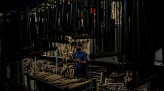 Pekerja membersihkan alat musik angklung di Saung Angklung Udjo di Bandung, Jawa Barat, Minggu (24/1/2021).  [ANTARA FOTO/Raisan Al Farisi]