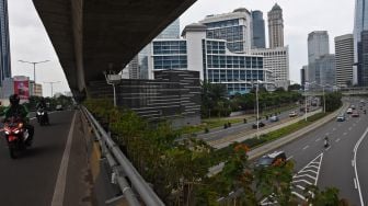 Sejumlah kendaraan bermotor melintas di kawasan Kuningan, Jakarta, Sabtu (23/1/2021).  ANTARA FOTO/Indrianto Eko Suwarso
