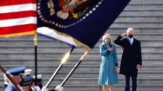 Presiden AS Joe Biden bersama Ibu Negara Jill Biden memberi hormat saat mereka meninjau kesiapan pasukan militer di tangga timur Capitol AS di Washington, DC, pada 20 Januari 2021, setelah dilantik di US Capitol.   [Foto/AFP]