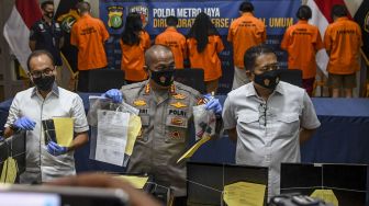 Kabid Humas Polda Metro Jaya Kombes Pol Yusri Yunus (tengah) didampingi Dirkrimum Polda Metro Jaya Kombes Pol Tubagus Ade Hidayat (kanan) menunjukkan barang bukti kasus pemalsuan surat keterangan hasil tes swab saat rilis di Ditreskrimum Polda Metro Jaya, Jakarta, Senin (25/1/2021). [ANTARA FOTO/M Risyal Hidayat]