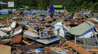 Sejumlah pekerja mencari sisa puing bangunan sekolah SMK 1 Rangas yang roboh pasca gempa bumi di Mamuju, Sulawesi Barat, Selasa (26/1/2021).  [ANTARA FOTO / Akbar Tado]