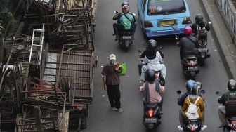 Warga mengenakan masker berjalan di kawasan Pasar Minggu, Jakarta, Selasa (26/1/2021). [Suara.com/Angga Budhiyanto]