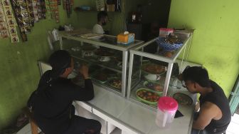 Pembeli menyantap makanan di Warteg Dias Berkah, Jati Padang, Pasar Minggu, Jakarta, Rabu (27/1/2021). [Suara.com/Angga Budhiyanto]