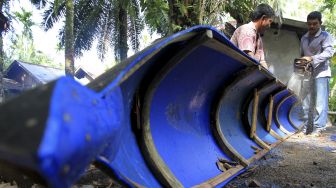 Perajin memotong bagian drum plastik bekas saat pembuatan perahu nelayan di Desa Teupin Perahu, Kecamatan Arongan Lambalek, Aceh Barat, Aceh, Jumat (29/1/2021). [ANTARA FOTO/Syifa Yulinnas]