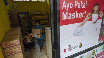 Warga memindahkan kardus di toko Tembako murah khusus untuk warga terdampak pandemi COVID-19 di Kampung Tangguh Jaya RW 9, Johar Baru, Jakarta Pusat, Sabtu (30/1/2021). [ANTARA FOTO/Aditya Pradana Putra]