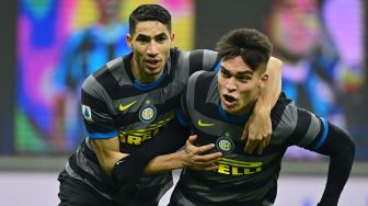 Penyerang Inter Milan Lautaro Martinez (kanan) merayakan golnya dengan bek Inter Milan Achraf Hakimi setelah mencetak gol selama pertandingan sepak bola Serie A Italia antara Inter Milan melawan Benevento,  di Stadion Guseppe Meazza, Minggu (31/1/2021) dini hari WIB. MIGUEL MEDINA / AFP