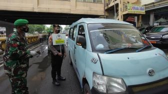 Personel gabungan TNI dan Polri membagikan masker saat kampanye Prokes COVID-19 di kawasan Pasar Tanah Abang, Jakarta, Minggu (31/1/2021). ANTARA FOTO/Reno Esnir