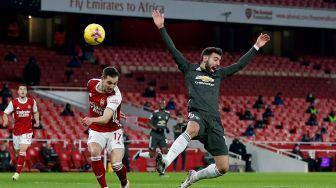 Bek Arsenal Cedric Soares (kiri) bersaing dengan gelandang Manchester United Bruno Fernandes selama pertandingan sepak bola Liga Premier Inggris antara Arsenal melawan Manchester United di Stadion Emirates, London, Sabtu waktu setempat, atau Minggu (31/1/2021) dini hari WIB. Ian KINGTON / IKIMAGES / AFP