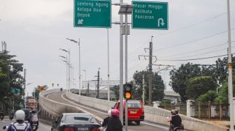 Warga mencoba membawa kendaraannya melewati Flyover Lenteng Agung di Jakarta Selatan, Minggu (31/1/2021). [Suara.com/Alfian Winanto]