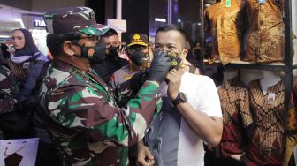 Panglima TNI Marsekal TNI Hadi Tjahjanto (kiri) bersama Kapolri Jenderal Pol Listyo Sigit Prabowo (tengah) memakaikan masker kepada warga saat melakukan kunjungan di Pasar Tanah Abang, Jakarta, Minggu (31/1/2021). ANTARA FOTO/Reno Esnir