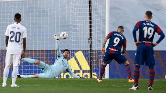 Penjaga gawang Real Madrid Thibaut Courtois menghentikan tendangan penalti selama pertandingan sepak bola liga Spanyol Real Madrid melawan Levante di Stadion Alfredo di Stefano, Madrid, Sabtu (31/1/2021). PIERRE-PHILIPPE MARCOU / AFP