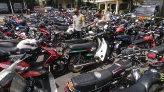 Polisi mengamati barang bukti sepeda motor hasil penindakan balap liar di Polres Kediri, Jawa Timur, Senin (1/2/2021). ANTARA FOTO/Prasetia Fauzani