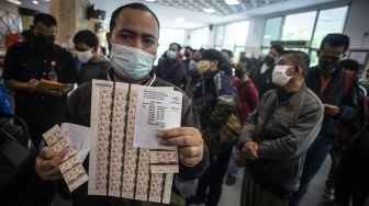 Seorang warga menunjukkan lembaran materai Rp10.000 yang dibelinya di Kantor Pos, Pasar Baru, Jakarta, Senin (1/2/2021). ANTARA FOTO/Aprillio Akbar
