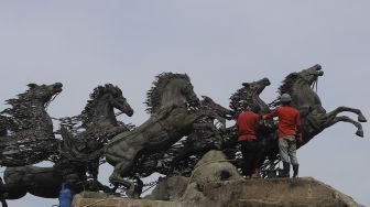 Pekerja melakukan perawatan patung Asta Brata (Arjuna Wijaya) di jalan Medan Merdeka Barat, Jakarta, Selasa (2/2/2021). [Suara.com/Angga Budhiyanto]