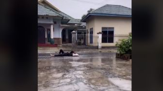 Demi Konten, Wanita Ini Hujan-hujanan hingga Tiduran di Jalan Pakai Bantal
