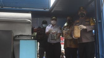 Kapolda Metro Jaya Irjen Fadil Imran (kanan) didampingi Wakil Gubernur DKI Jakarta Ahmad Riza Patria (kedua kiri) dan Kepala BNNP DKI Jakarta Brigjen Pol Tagam Sinaga (tengah) bersiap memasukkan barang bukti narkoba ke dalam mesin pemusnah di Mapolda Metro Jaya, Jakarta, Rabu (3/2/2021). [Suara.com/Angga Budhiyanto]