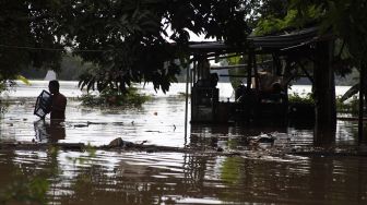 Warga melintasi banjir yang menggenangi permukiman di Kampung Sewu, Jebres, Solo Jawa Tengah, Kamis (4/2/2021). [ANTARA FOTO/Maulana Surya]